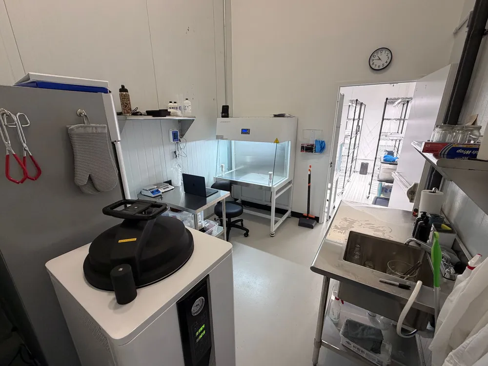 Wide overview of a fully designed and equipped tissue culture lab with autoclave, laminar flow hood, microscope station, and prep sink